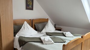 Una cama doble con dos almohadas, una mesita de noche y un cuadro enmarcado en la pared.