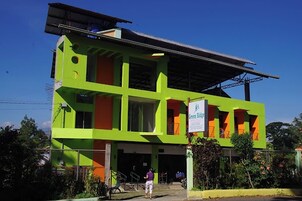 A two-story building with a green and orange facade, a sign reading "Green Ridge," and a covered entrance area.