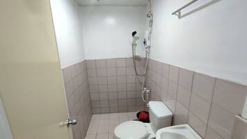 A small bathroom with a toilet, bidet, and shower.