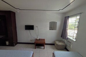 A room with two beds, a small table, a TV mounted on the wall, and a window with curtains. - Green Ridge Apartelle By Zuzu (Malaybalay City)