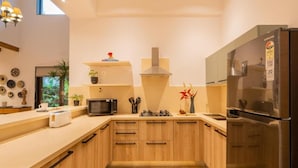 Una cocina moderna con armarios de madera, un refrigerador de acero inoxidable, un microondas y una estufa a gas.