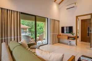 A modern living room with a sofa, a flat-screen TV, and a balcony with a chair. - Elivaas Shai - Goa (Assagao)