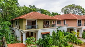 A row of two-story houses with balconies, surrounded by lush greenery. - Elivaas Shai - Goa (Assagao)