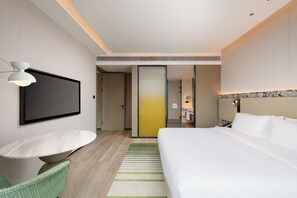 A modern hotel room with a bed, a dining table, and a TV. - Holiday Inn Fuzhou Exhibition Center (Fuzhou)