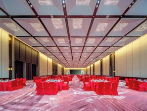 A conference room with red chairs and tables, a patterned carpet, and a modern ceiling with recessed lighting. - Holiday Inn Fuzhou Exhibition Center (Fuzhou)