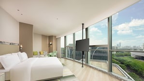 A modern hotel room with a large bed, a TV, and a balcony with a city view. - Holiday Inn Fuzhou Exhibition Center (Fuzhou)