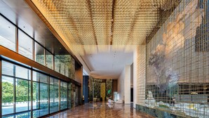 A spacious lobby with a reflective marble floor, large windows offering a view of greenery, and a ceiling adorned with hanging lights. - Holiday Inn Fuzhou Exhibition Center (Fuzhou)