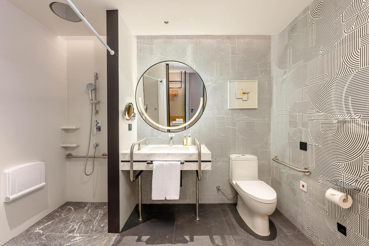 A modern bathroom with a shower, toilet, and sink.