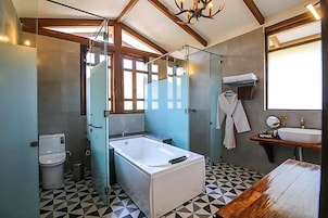 Un bagno moderno con doccia a vetro, vasca da bagno indipendente, lavandino con specchio e mobile bagno in legno.