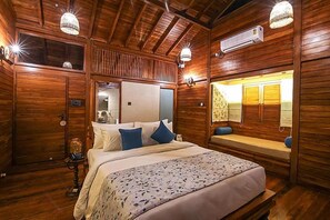 Een houten kamer met een bed, een bankje en een spiegel.