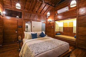 Una habitación de cabaña de madera con una cama, un banco y un espejo.