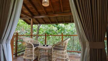 A covered outdoor seating area with wicker furniture and a hanging light fixture.
