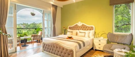 Un dormitorio con cama, mesita de noche, silla, ventana y balcón.