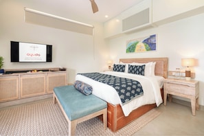 A modern hotel room with a bed, bedside table, bench, TV, artwork, and a mounted television displaying 'ayuda' logo. - Ayuda Sanctuary Boutique Negombo (Negombo)