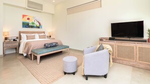 Un dormitorio moderno con cama, mesita de noche, lámpara, televisor y un banco.