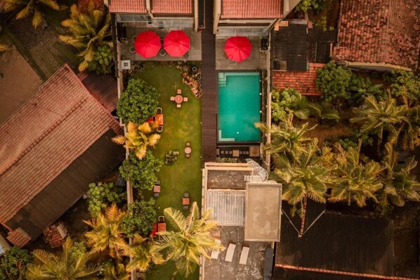 An aerial view of a property with a swimming pool, outdoor seating, and palm trees. - Ayuda Sanctuary Boutique Negombo (Negombo)