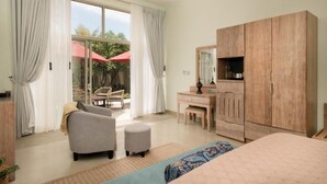 A bedroom with a bed, a wooden wardrobe, a desk, a chair, and a large window with curtains. - Ayuda Sanctuary Boutique Negombo (Negombo)