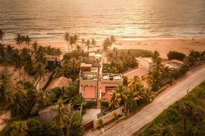 An aerial view of a coastal property with multiple buildings, palm trees, and a beach. - Ayuda Sanctuary Boutique Negombo (Negombo)