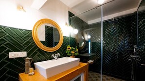 A bathroom with a wooden vanity, a large mirror, a sink, and a shower area. - Elivaas Bludoor - Goa (Assagao)
