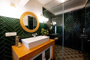 A bathroom with a wooden vanity, a large mirror, a sink, and a shower area. - Elivaas Bludoor - Goa (Assagao)