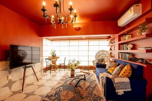 A living room with a TV, sofa, and decorative items. - Elivaas Bludoor - Goa (Assagao)