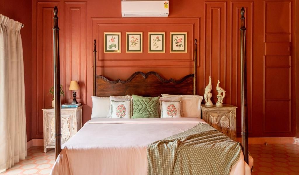 A four-poster bed with a wooden headboard, a bedside table with a lamp, and a wall-mounted air conditioner.