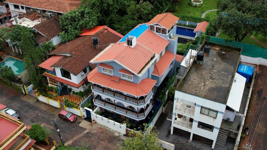 A multi-story building with a red-tiled roof, a swimming pool, and a small garden area.