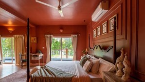 A bedroom with a bed, a desk, a chair, a ceiling fan, and a window with curtains. - Elivaas Bludoor - Goa (Assagao)