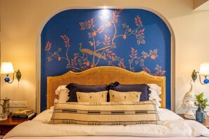 A bed with a woven headboard, a decorative wall mural, and bedside lamps. - Elivaas Bludoor - Goa (Assagao)