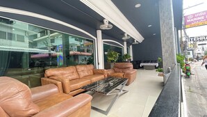 Un espace extérieur moderne, aménagé avec des canapés en cuir et une table en marbre noir.