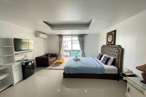 A modern hotel room with a bed, a TV, a desk, and a small kitchenette. - W-9 Hotel By Zuzu (Pattaya)