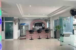 Une cuisine moderne avec une arche en briques, un réfrigérateur et un coin bar avec des tabourets.