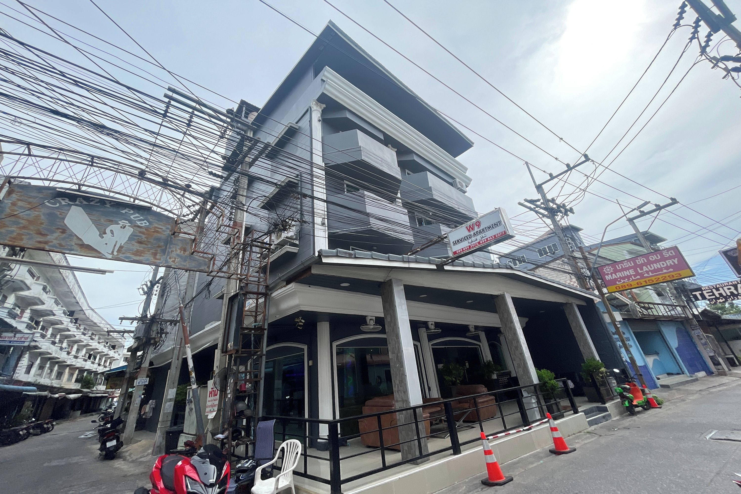 A multi-story building with a sign for "Crazy Pub" and "KW9 Serviced Apartments."
