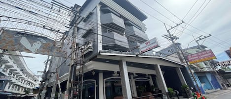 A multi-story building with a sign for "Crazy Pub" and "KW9 Serviced Apartments."
