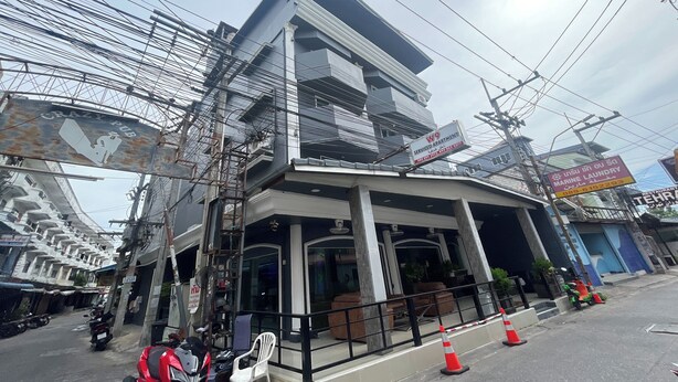 A multi-story building with a sign for "Crazy Pub" and "KW9 Serviced Apartments." - W-9 Hotel By Zuzu (Pattaya)