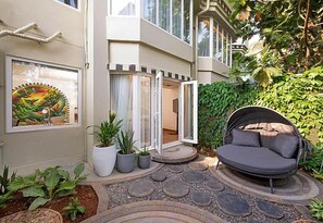 A modern building with a circular seating area, potted plants, and a large window with artwork. - The Orchid Passaros (Benaulim)