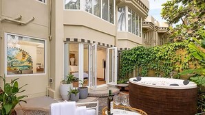 A spa area with a hot tub, outdoor seating, and potted plants. - The Orchid Passaros (Benaulim)