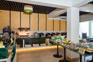 A modern kitchen with a marble countertop, various cooking appliances, and a buffet area with labeled food items. - The Orchid Passaros (Benaulim)