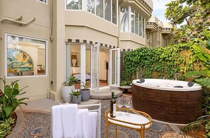 A spa area with a hot tub, outdoor seating, and potted plants. - The Orchid Passaros (Benaulim)