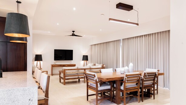A modern living room with a dining area, wooden furniture, a flat-screen TV, and a ceiling fan. - Bohari (San José del Cabo)