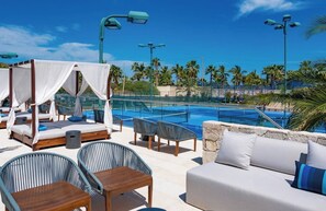 A poolside area with a canopy bed, lounge chairs, and a sofa. - Bohari (San José del Cabo)
