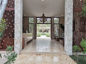 A reception area with a stone wall, a reception desk, and a decorative gate. - Bohari (San José del Cabo)