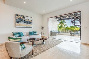 A modern living room with a sofa, armchair, coffee table, and artwork. - Bohari (San José del Cabo)