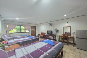 Une chambre avec deux lits, un bureau, une télévision et un réfrigérateur.