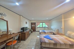A hotel room with a desk, two beds, a television, and a window with curtains. - Phaiboon Hotel & Resort By Zuzu (Pak Chong)