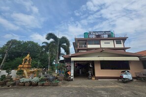 A two-story building with a signboard, a small shrine, and potted plants in front. - Phaiboon Hotel & Resort By Zuzu (Pak Chong)