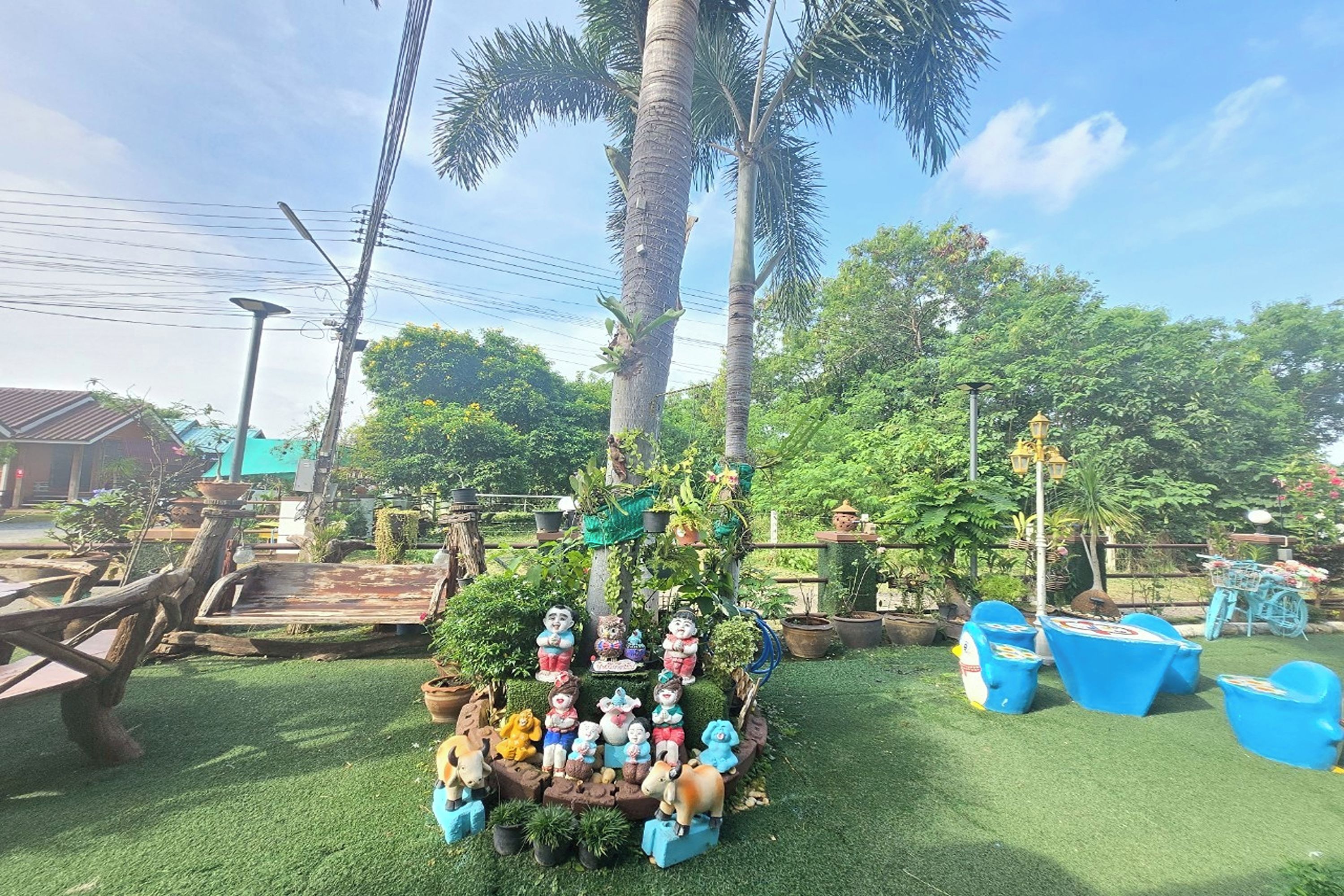 A garden area with a central decorative arrangement featuring various figurines and a small fountain.