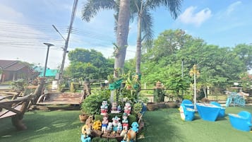 A garden area with a central decorative arrangement featuring various figurines and a small fountain.
