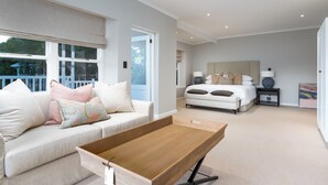 A modern bedroom with a large bed, a bedside table, and a window with a view of the outside. - Bay Haven Collection, Hout Bay (Cape Town)