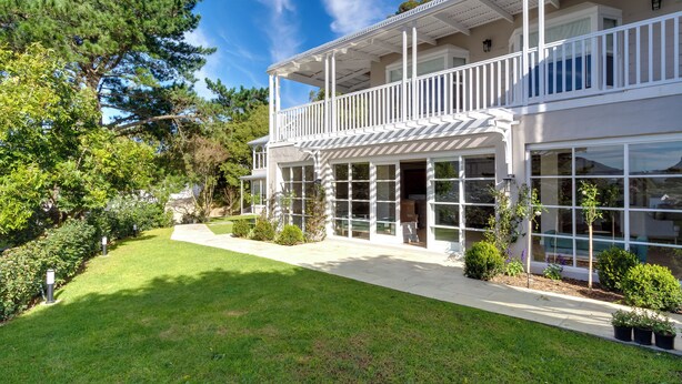 A two-story house with a balcony, large windows, and a well-maintained lawn. - Bay Haven Collection, Hout Bay (Cape Town)